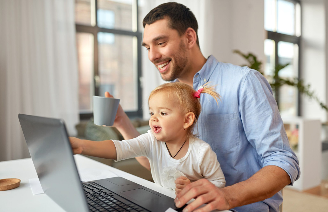 Vater mit Kind vor Notebook